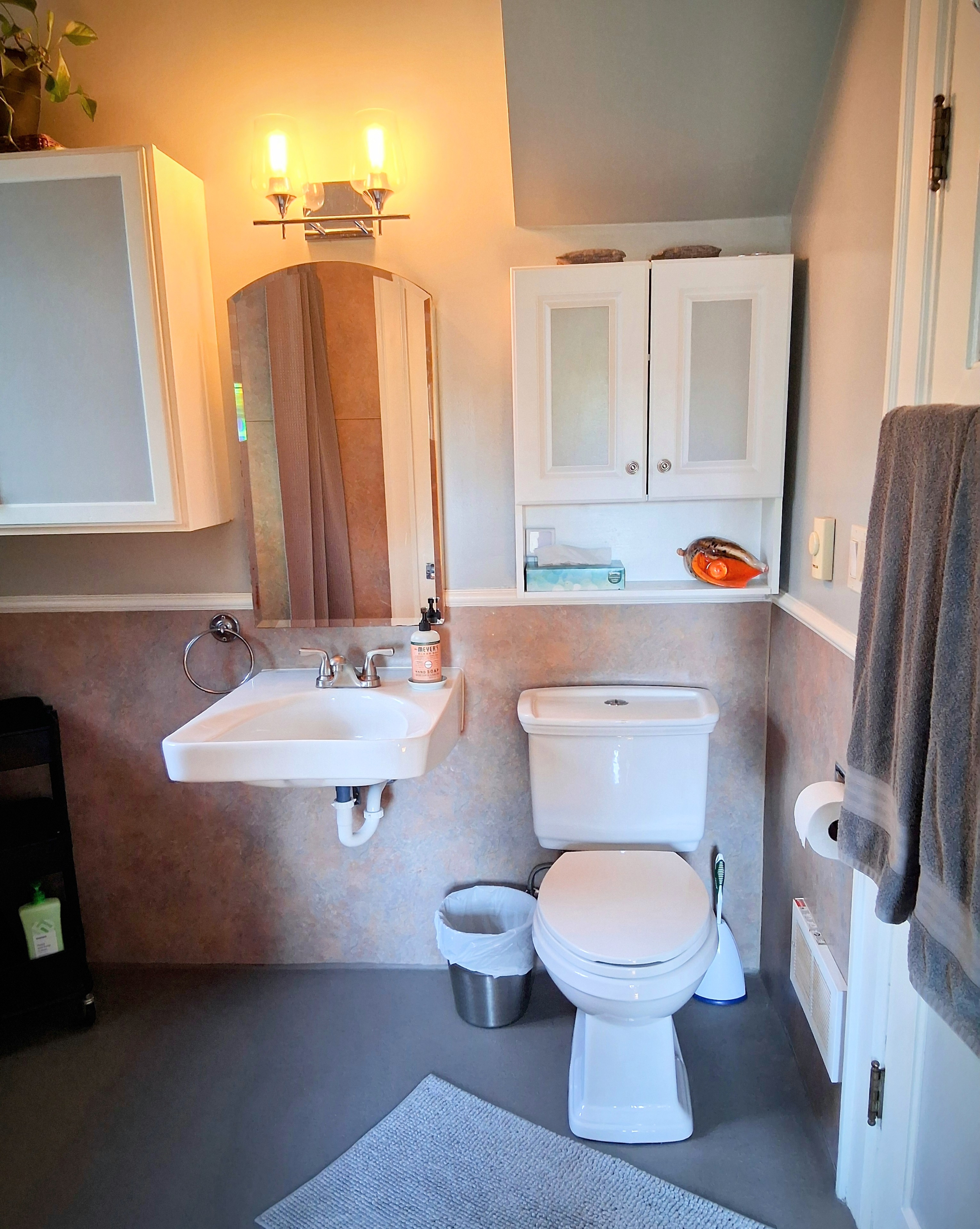 It's a very simple, but super clean, 3/4 bathroom with shower. A sliding door opens from the main bedroom. Towels hang on another door to the hallway.