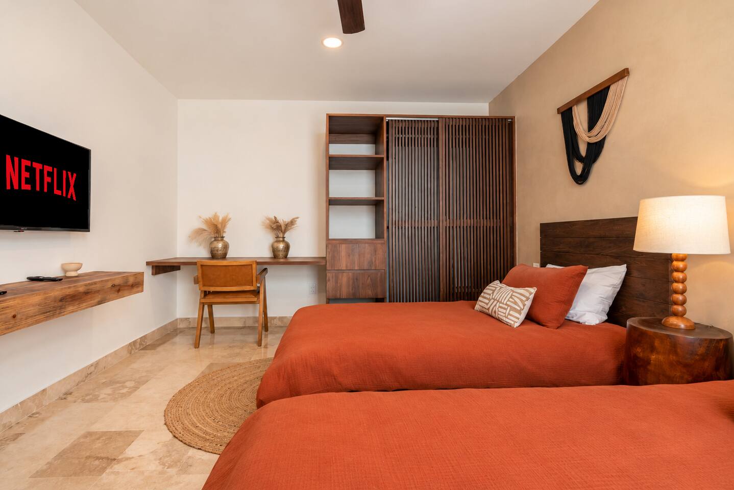 Esta recámara cuenta con 2 camas individuales, aire acondicionado, ventilador de techo, amplio ropero y un espacio de trabajo dedicado, ideal para huéspedes que necesitan trabajar a distancia durante su estancia.