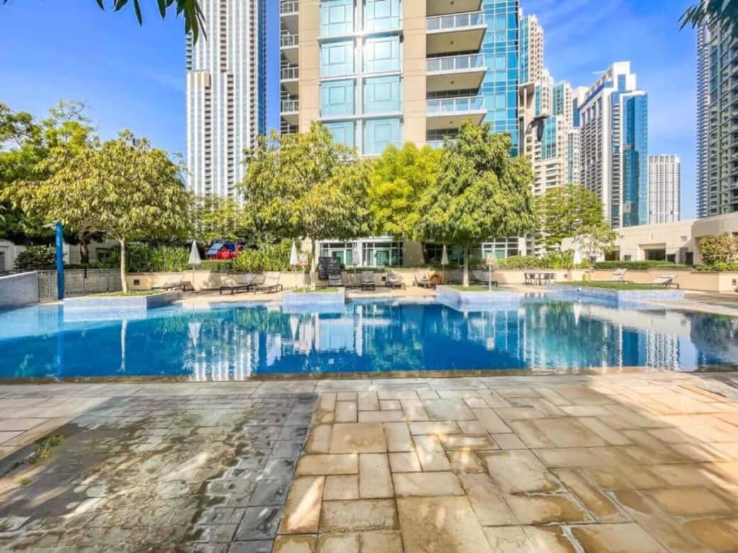 Outdoor swimming pool with loungers and skyline views—unwind and enjoy leisure time in a resort-style setting.