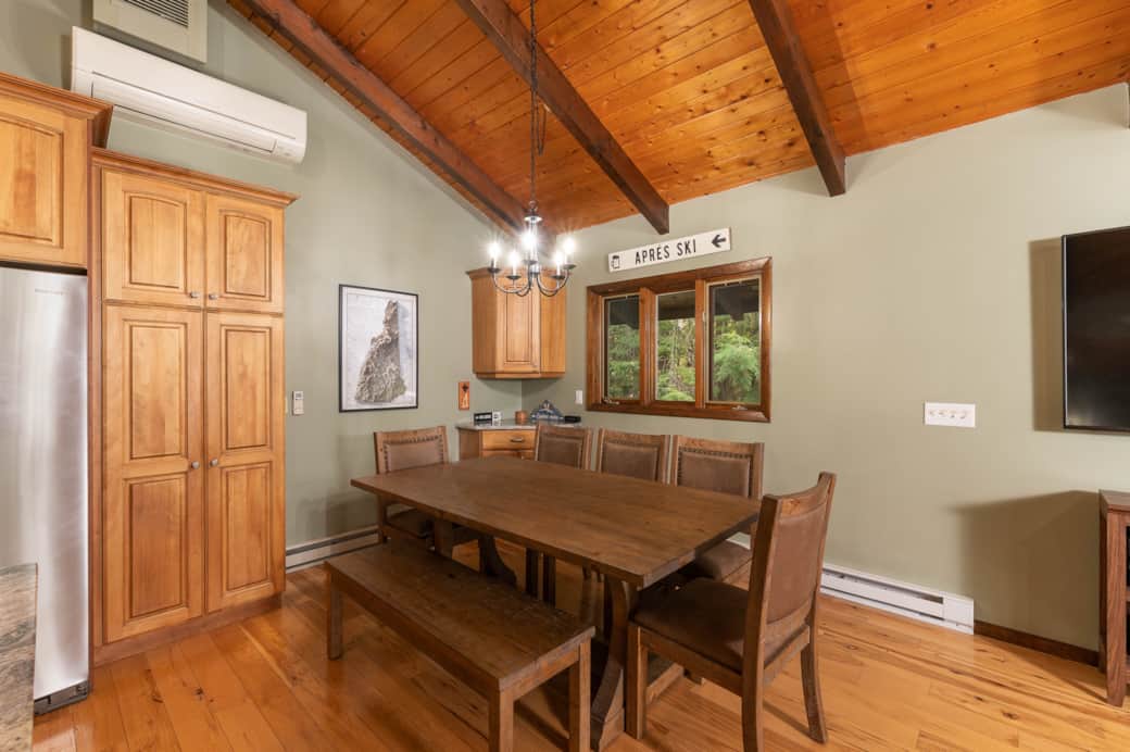 A dining table provides seating for up to 8, while the corner bar is stocked with glasses. A dining table provides seating for up to 8, while the corner bar is stocked with glasses.