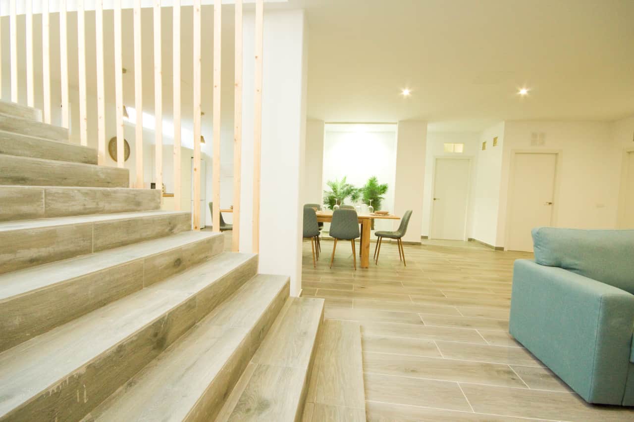 Grand salon avec salle à manger et escalier design à la Casa Vica, location de vacances proposée