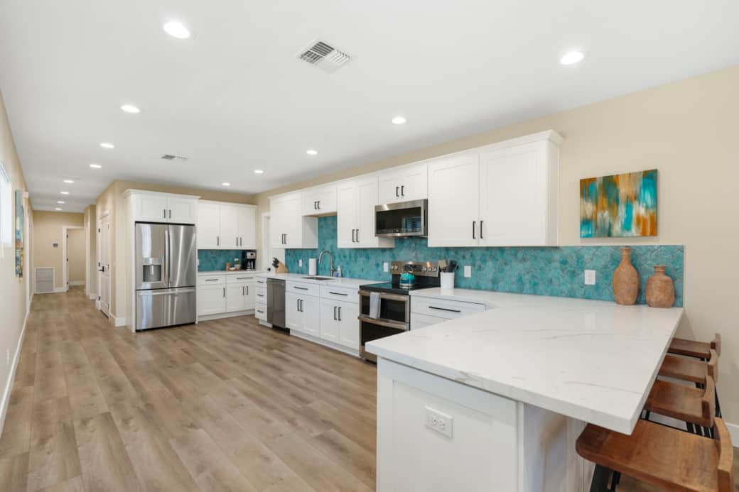 Welcoming entryway with a massive wall-mounted Smart TV and comfortable lounge seating. Unit 1.