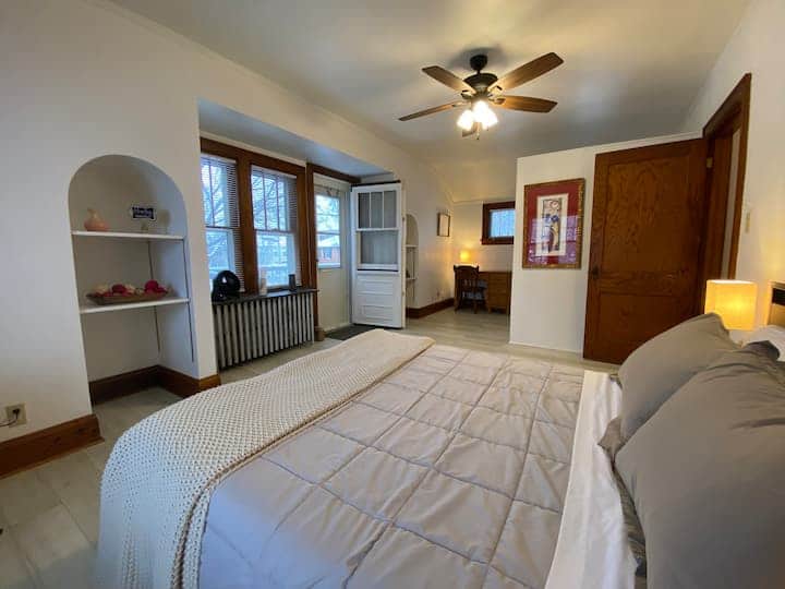 Bright and inviting private bedroom with warm natural light and classic charm.
