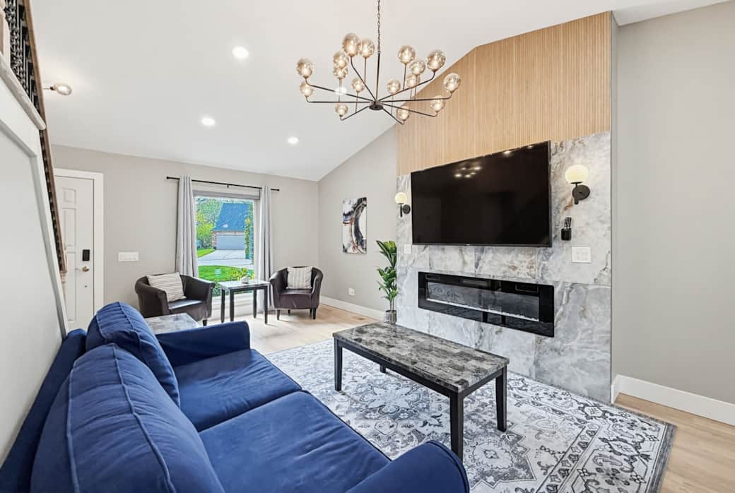 Living Room 1: Sun-drenched main living area with vaulted ceilings and a large flat-screen TV.
