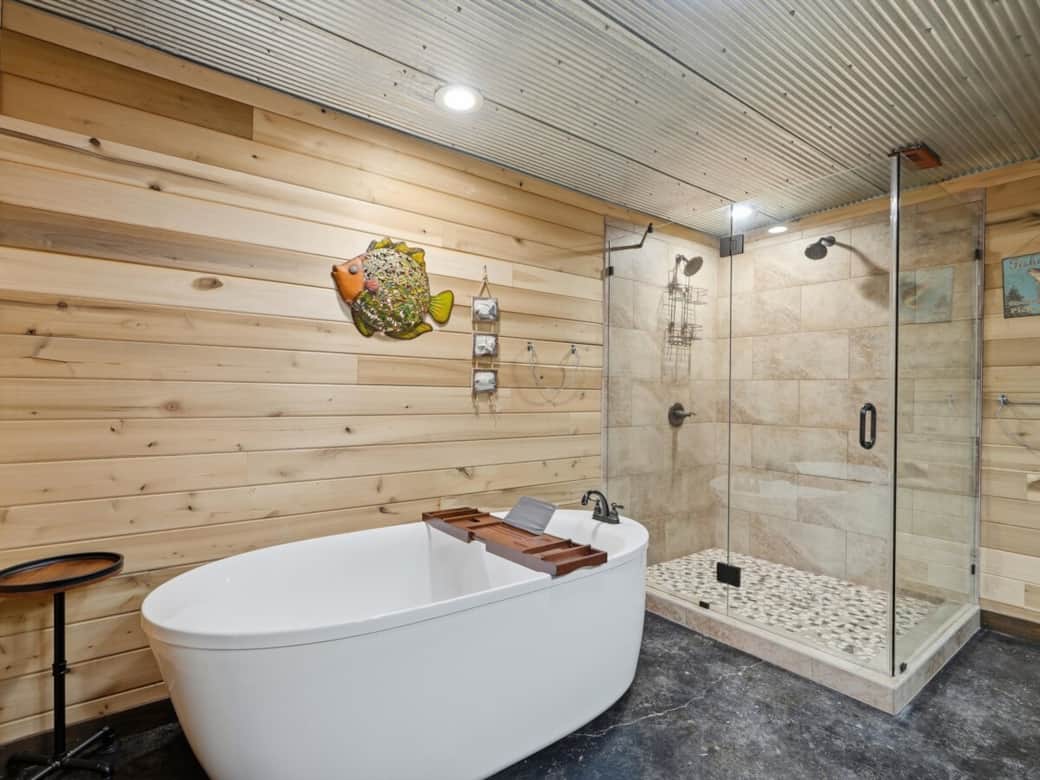 Bathroom features a soaking tub, two-headed shower, and double vanity with two sinks. Guests will enjoy provided towels, shampoo, conditioner, and soap for a comfortable and convenient stay.
