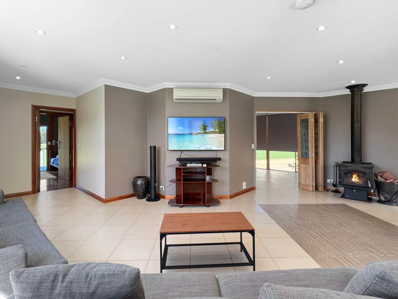 Living room with fire pit, AC, and TV for cozy relaxation.