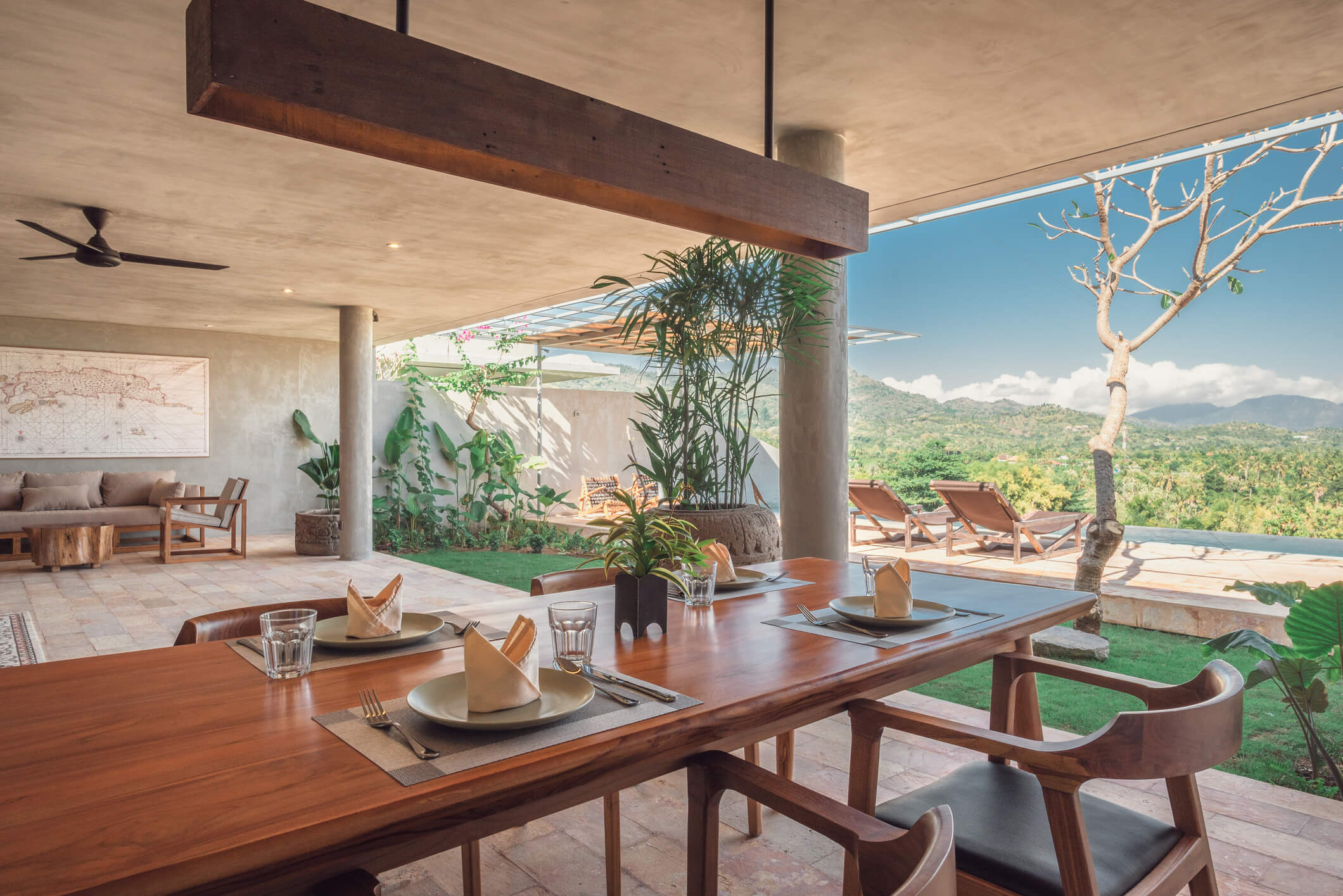 Open-air dining at Villa Asti, Sumberkima Hill, Bali, with mountain view, lounge and terrace loungers by the infinity pool.