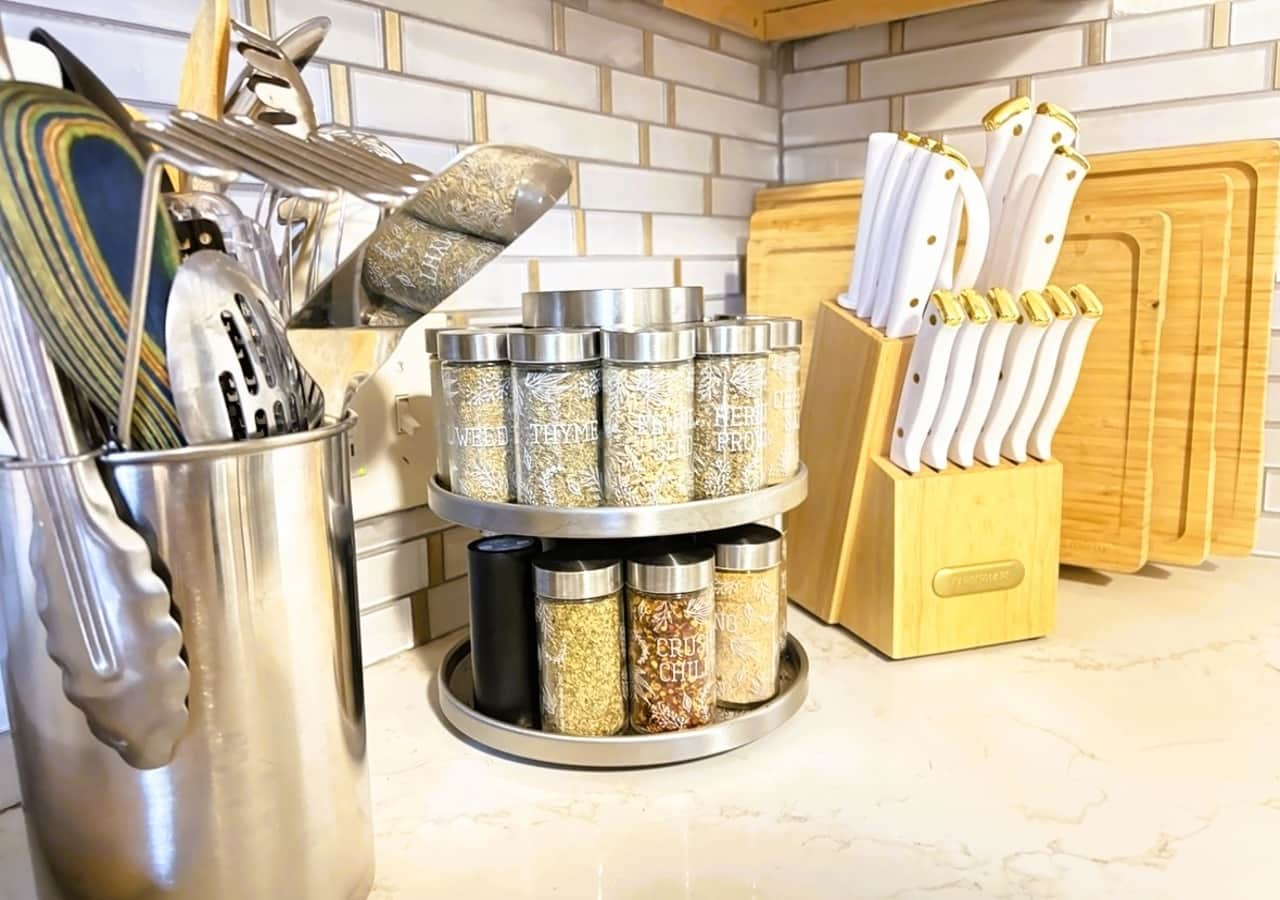 Lots of spices, cooking utentils, knives, and cutting boards.