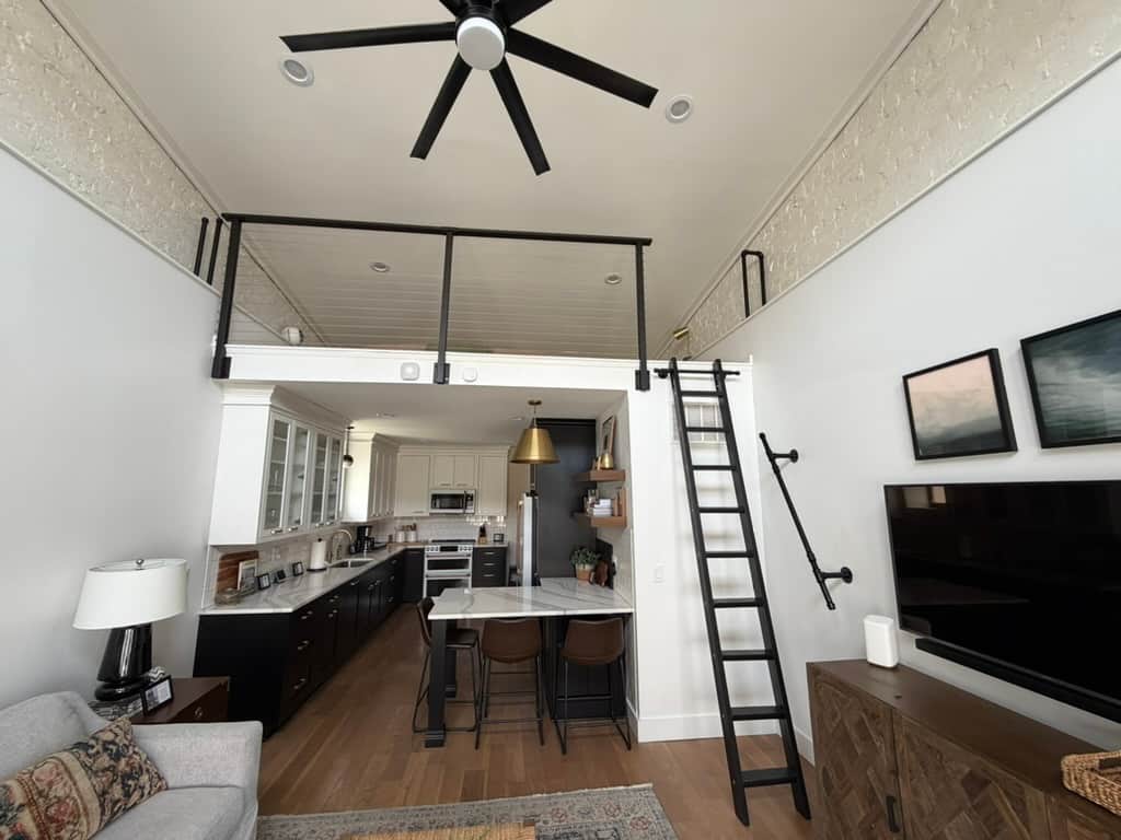 Full loft view over living room. Low ceiling at head—use caution. Extra sleeping space.