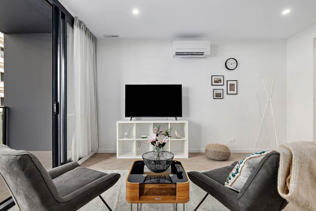 This inviting living space is designed for both comfort. With a sleek coffee table, comfortable seating, and a flat-screen TV, it's perfect for socializing or enjoying some downtime. The open layout and natural light create a warm atmosphere.