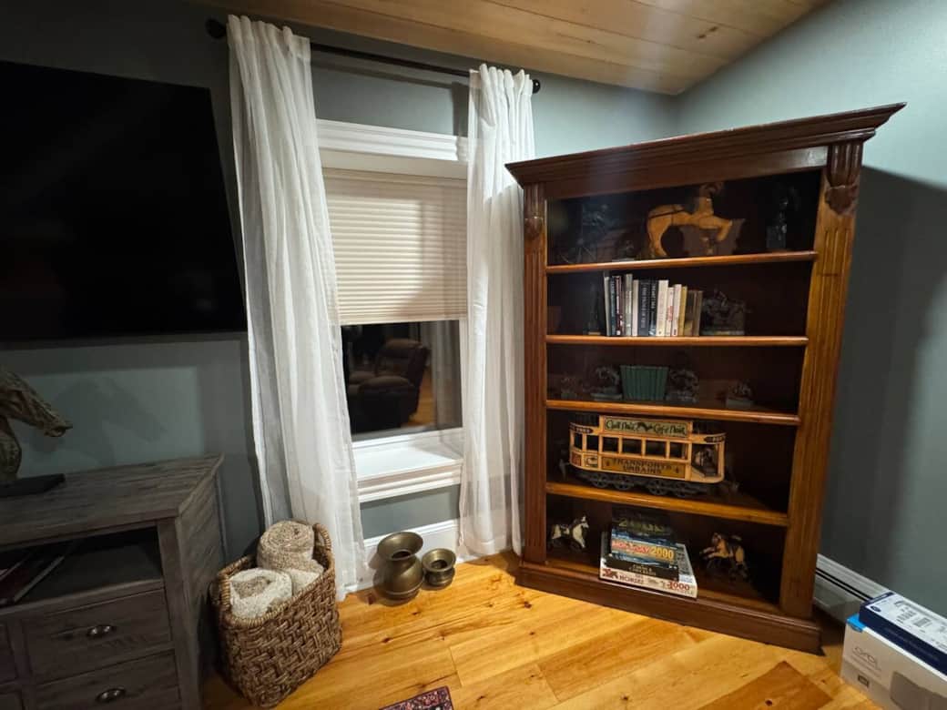 Cozy reading nook with books, games, and warm rustic décor.