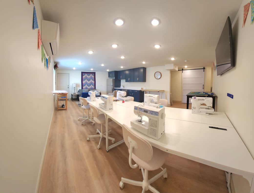 Sewing studio for six has two cutting tables, two ironing stations, and comfortable sewing chairs. Sewing studio for six has two cutting tables, two ironing stations, and comfortable sewing chairs.