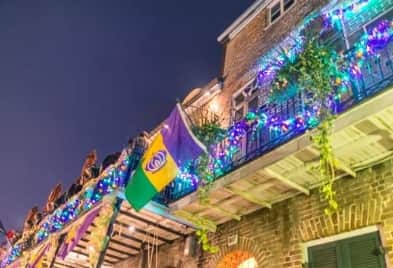 Mardi Gras balcony party view overlooking The Strand in Galveston with parade below