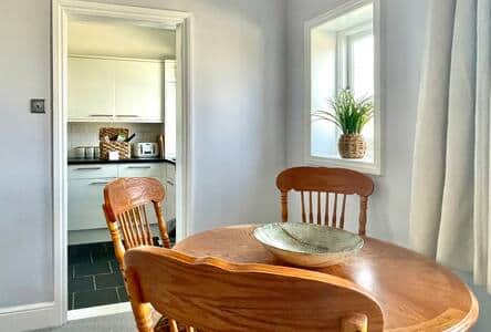 Large dining table with four padded chairs