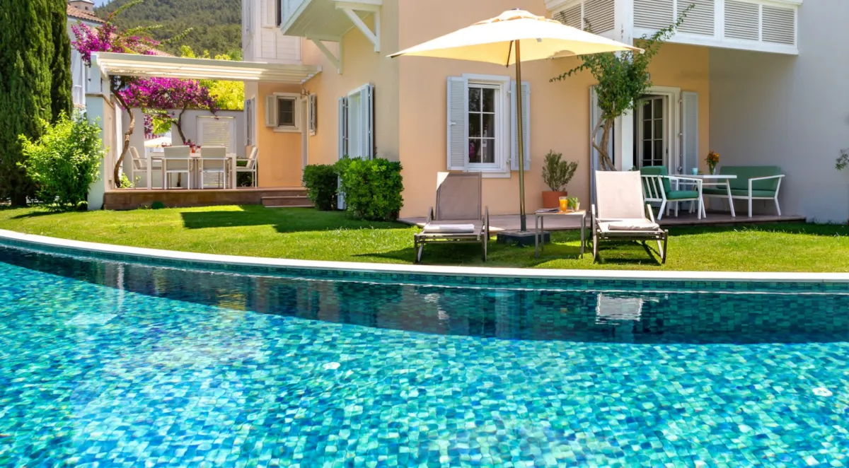 Swimming pool surrounded by lawn chairs and a garden, Portville B2 005, Göcek