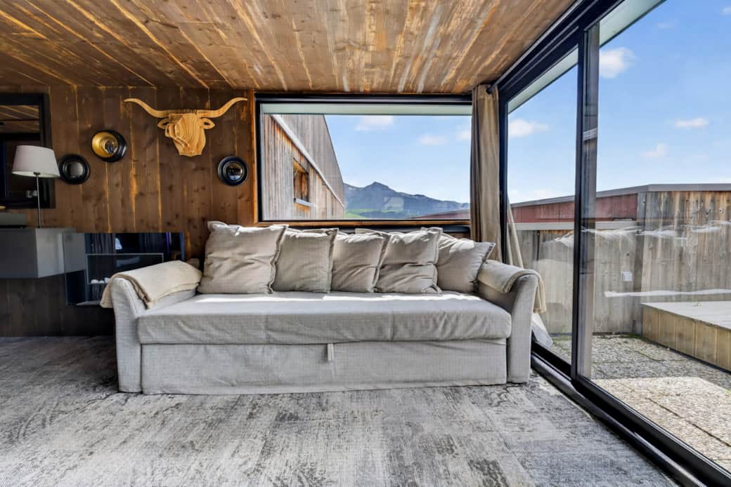 Sofa bed facing the panoramic bay window overlooking the mountains. Sofa bed facing the panoramic bay window overlooking the mountains.