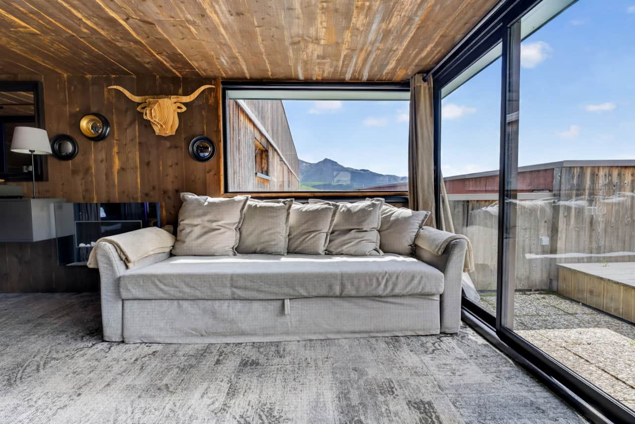 Sofa bed facing the panoramic bay window overlooking the mountains.