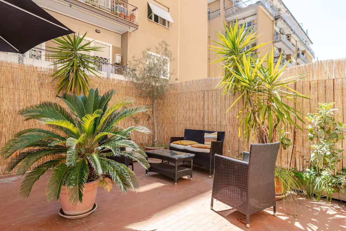 Terrazzo arredato con tavolo da pranzo e ombrellone.