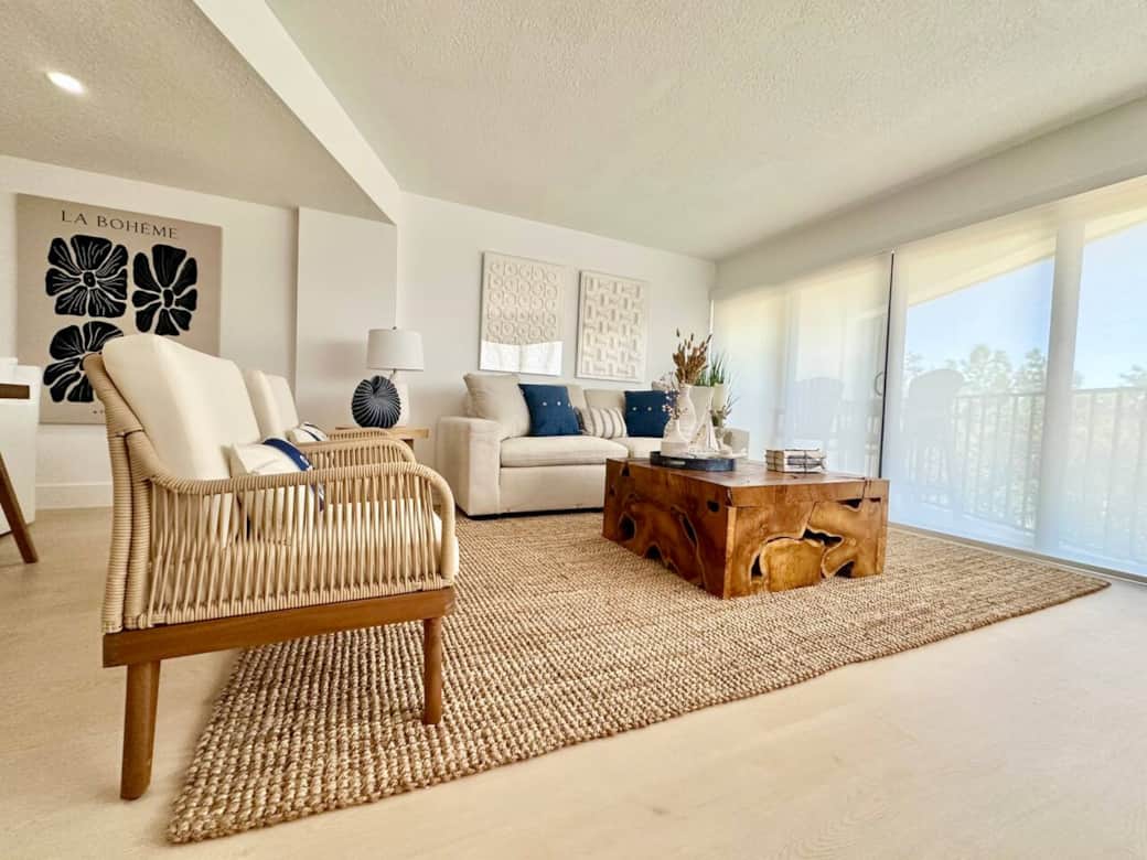 Relax in the open-concept living space filled with natural light and soft ocean tones