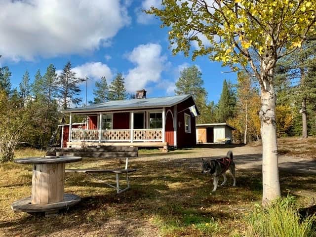 Frontside of the cabin with toilet and wood shed behind