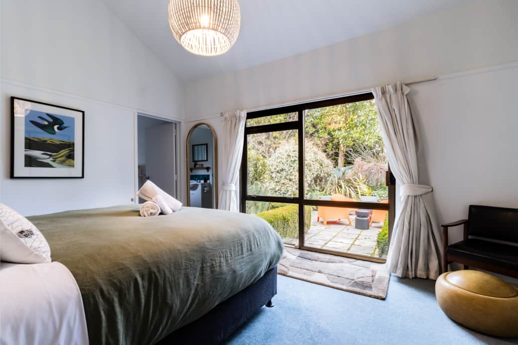 Master bedroom with patio views, full-length mirror, and bedside wireless charging stations.