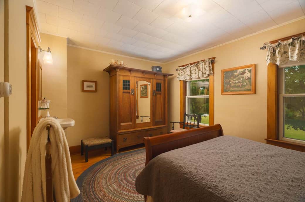 Windows bring in natural light, highlighting the armoire and decor. Windows bring in natural light, highlighting the armoire and decor.