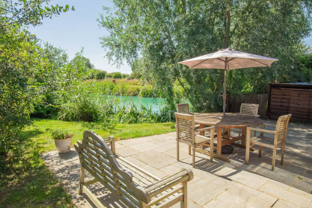 The patio with outside dining and garden area with lake views. BBQ & four loungers in outside store.