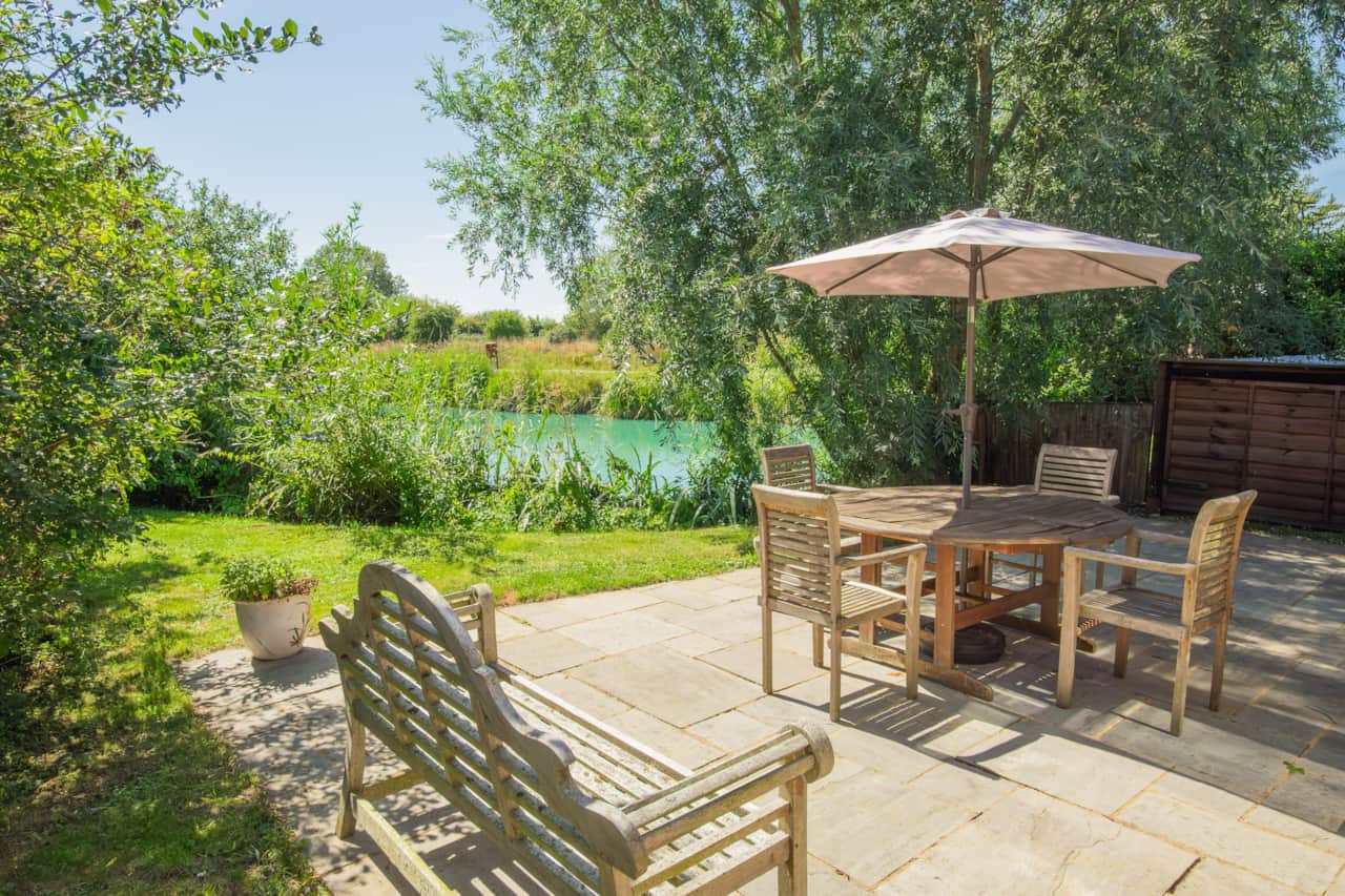 The patio with outside dining and garden area with lake views. BBQ & four loungers in outside store.