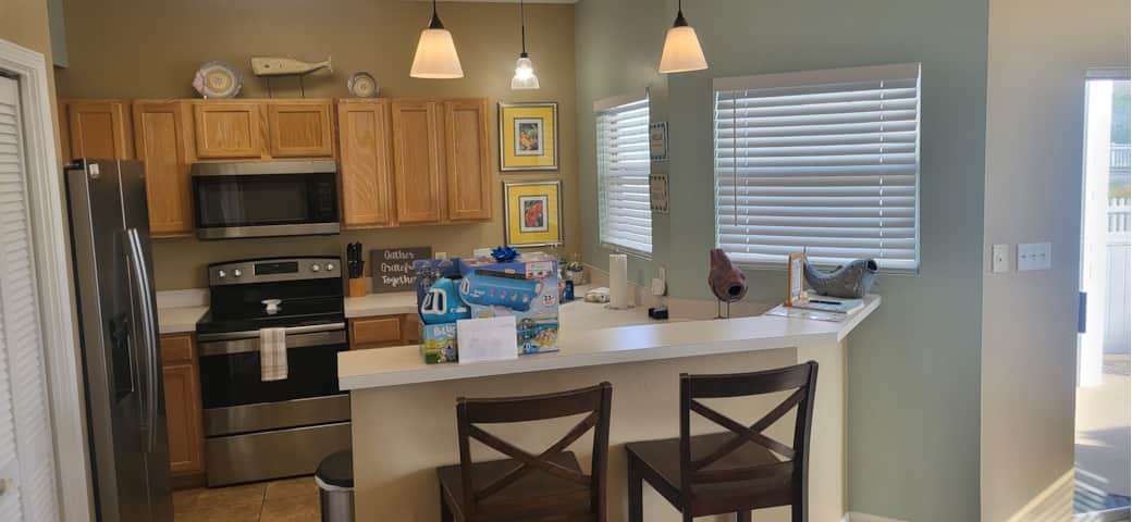 Fully stocked kitchen with modern appliances and casual breakfast bar seating. Fully stocked kitchen with modern appliances and casual breakfast bar seating.