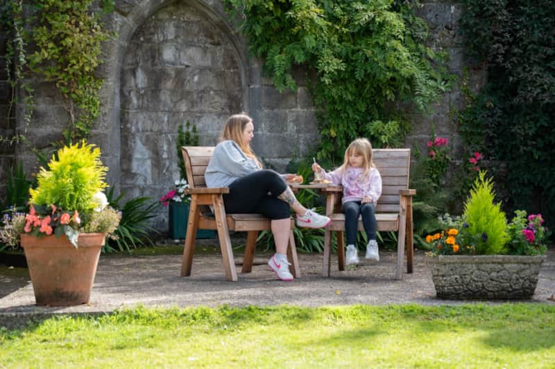 A mother and daughter sitting together on garden seats