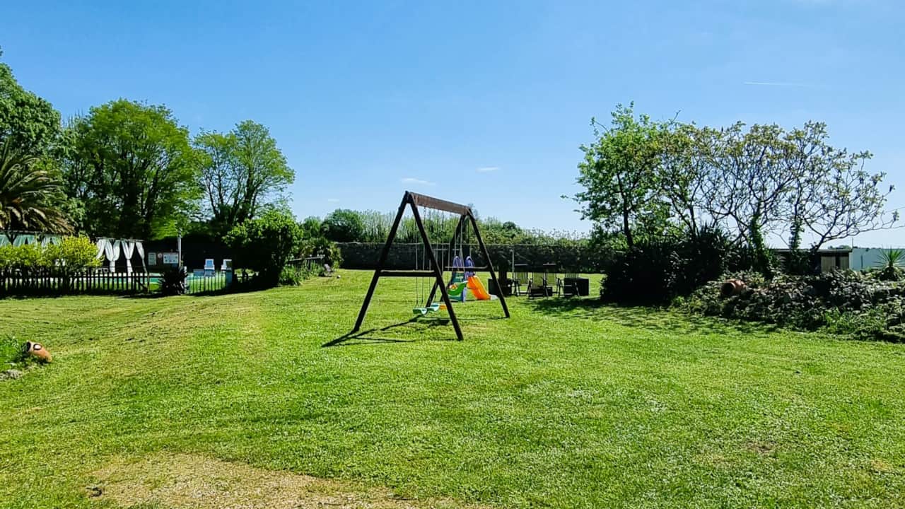 Tree-lined garden with children's swing set
