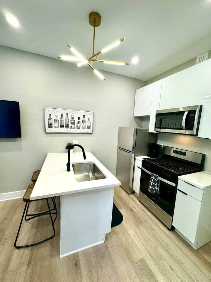This beautiful kitchen, where you’ll find a quartz island with bar stools, perfect for enjoying meals or hanging out with friends. The kitchen is equipped with a refrigerator, microwave, and dishwasher, along with all the basic cooking essential.
