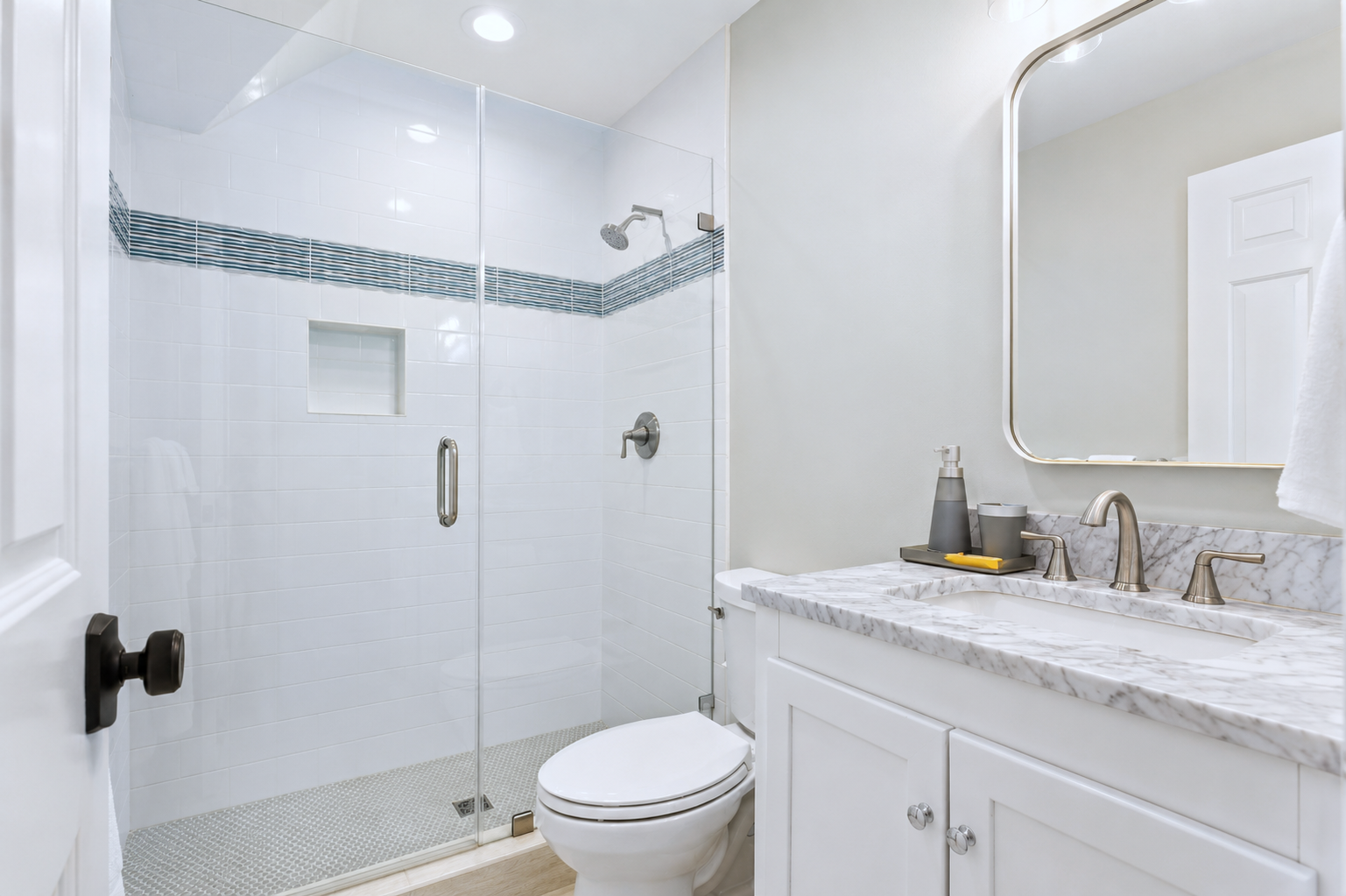 Freshen up in the glass shower, then use the spacious vanity and mirror to get ready for the day.