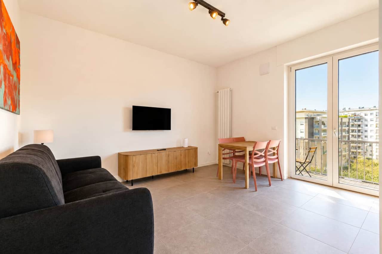Soggiorno accogliente con divano letto, smart tv, wifi, tavolo da pranzo, cucina open space, accesso al balcone 