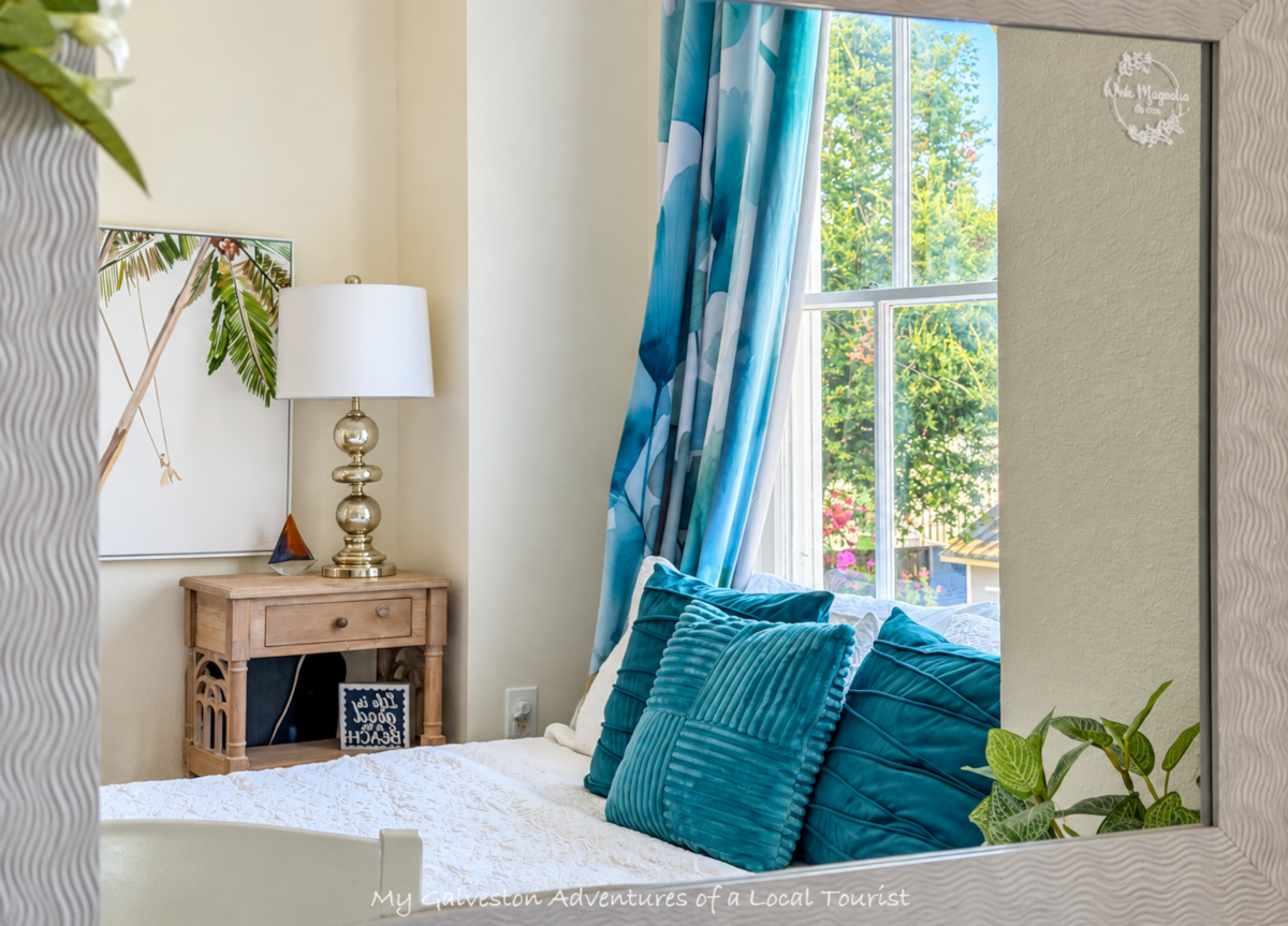 Close-up of luxury linens and pillows on the queen bed at White Magnolia Galveston