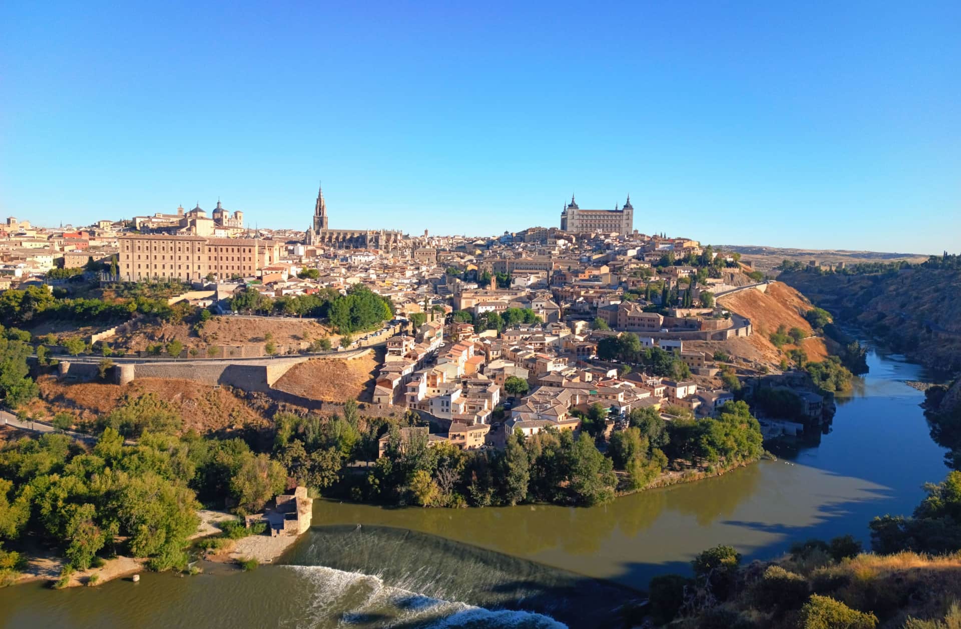 Casa rural cerca de Toledo - La Casita de Ale, ideal para escapadas culturales y Puy du Fou Vista panorámica de Toledo desde la distancia, con el Alcázar y la Catedral destacando sobre el río y el paisaje histórico