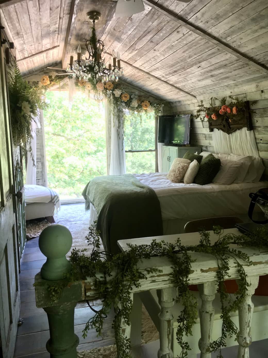 Upstairs bedroom is like a secret garden escape with giant windows to soak in nature Upstairs bedroom is like a secret garden escape with giant windows to soak in nature