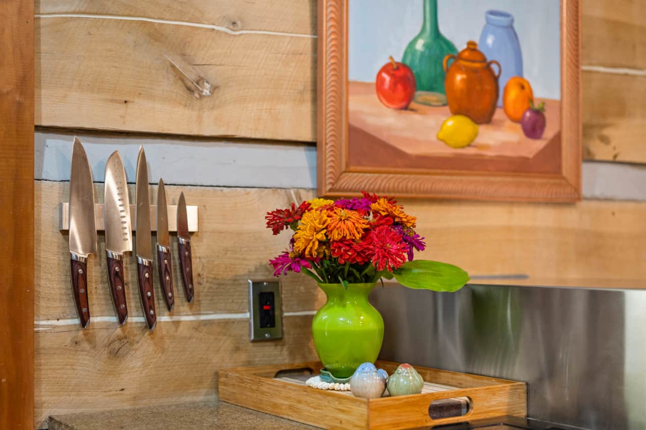 Well stocked kitchen for the avid chef with knives, granite counters, and original art.  