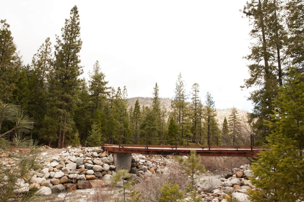 To get to the cabin, cross this sturdy bridge and then the cabin is just to your right along a dirt path as you follow the flowing creek. 