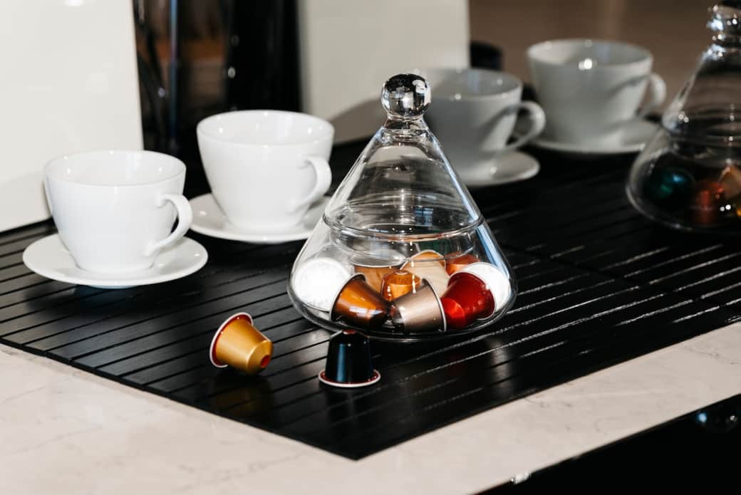 Free espresso pods sample provided. Enjoy a tranquil coffee time with our exquisite cup set, elegantly arranged on a black tray. It's the perfect setup for a relaxing break and enjoy your time.