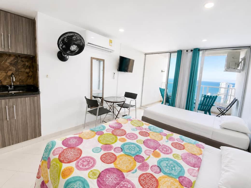 Dos camas sencillas y cama doble, cocina, vista al balcón