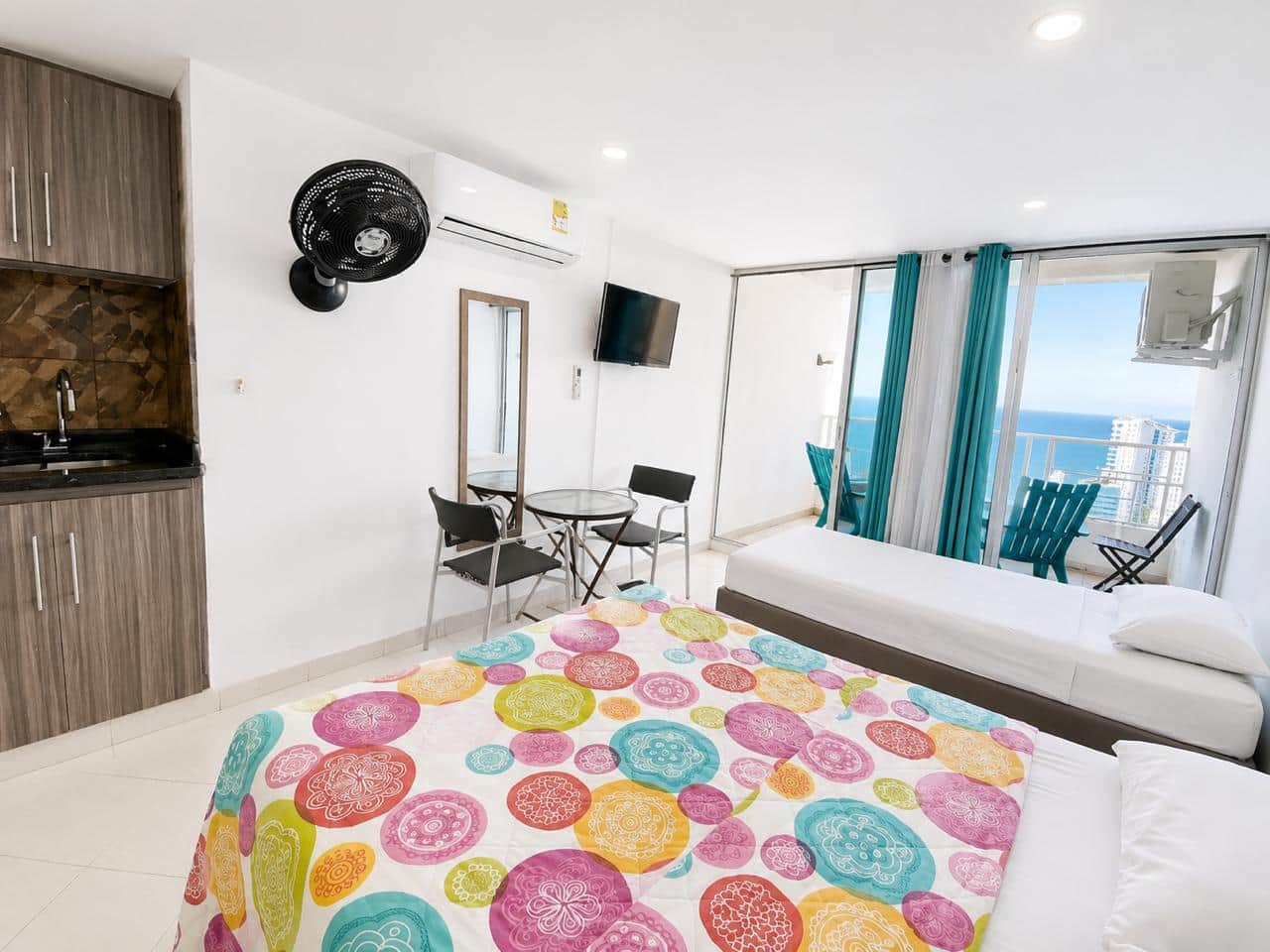 Dos camas sencillas y cama doble, cocina, vista al balcón