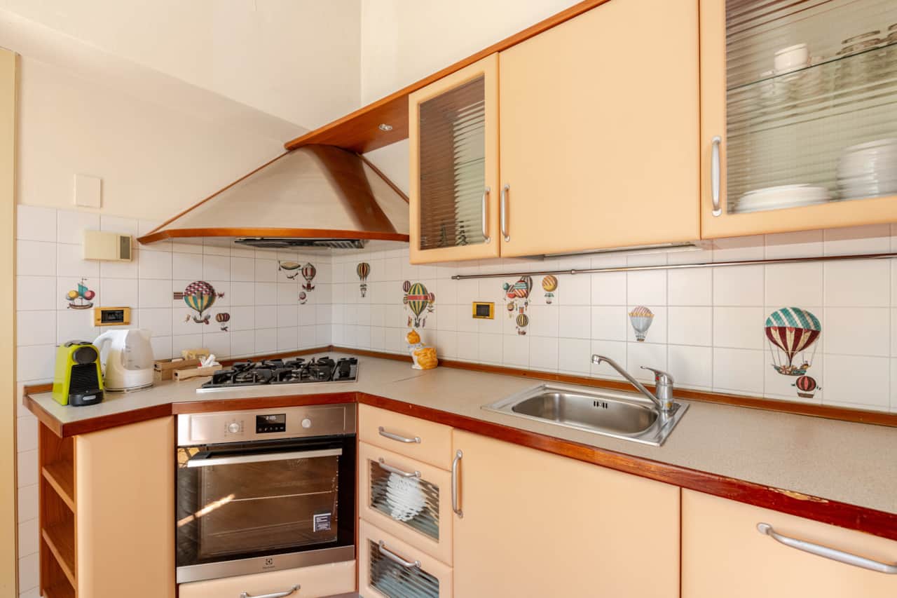 Cucina con forno, lavandino e piastrelle decorate