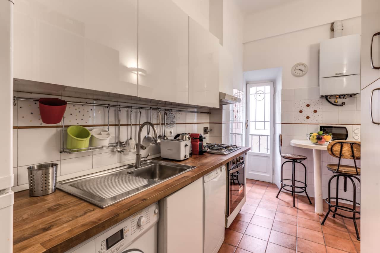 Fully equipped kitchen with tableware, utensils, and kitchen appliances
