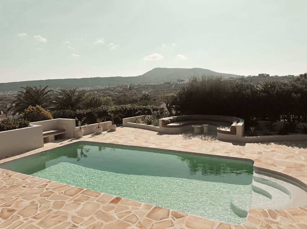 Uitzicht vanaf het terras over het privézwembad en grote ronde loungebank.