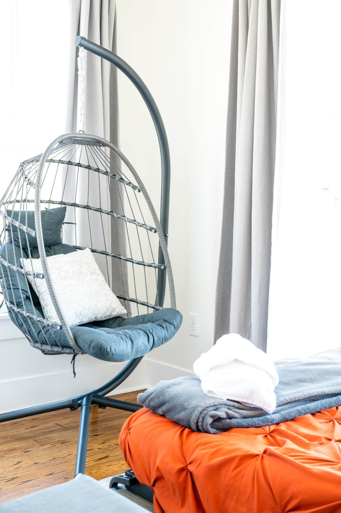Swing chair beside a coastal window view.