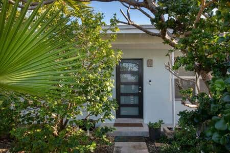 The entrance to this luxurious pool home is private and lush.