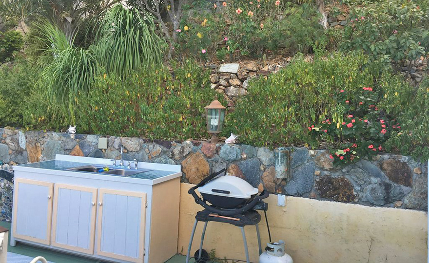 Outdoor prep area amid gardens in front and behind