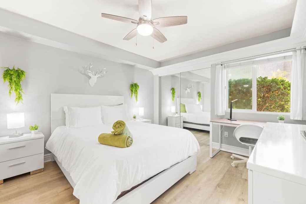 Bright, modern bedroom with minimalist decor and a dedicated workspace by the window.