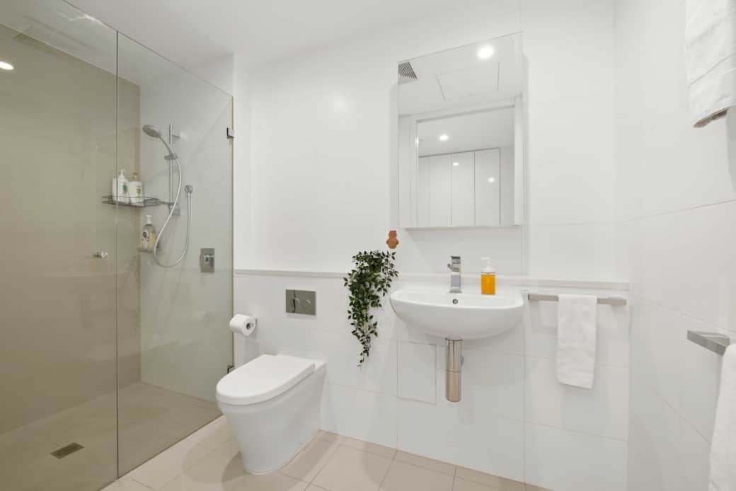 Step into a fresh, modern bathroom with a spacious walk-in shower, sleek fixtures, and bright lighting. Everything is sparkling clean and thoughtfully arranged for your comfort, offering a calming space to refresh and unwind during your stay.
